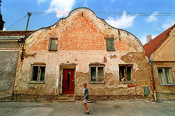 A boy walking past a house in Slavonice, the Czech Republic.