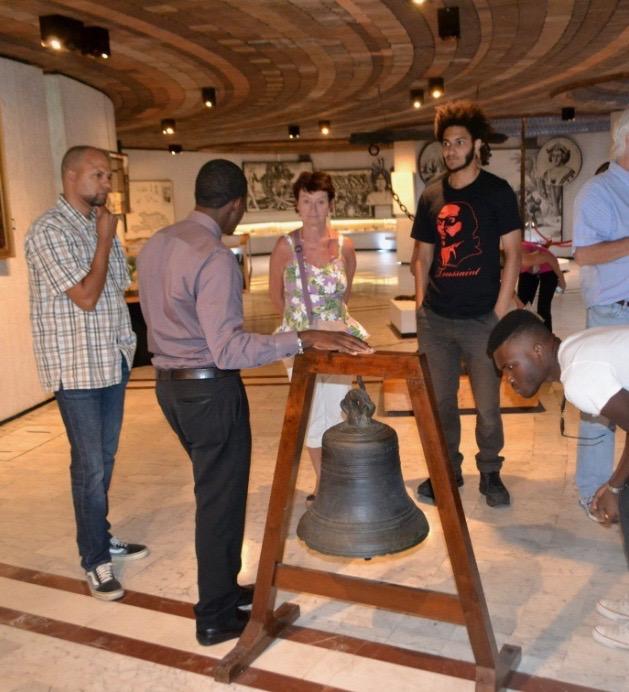 Alex Bien-Aimé showing visitors of MUPANAH museum in Port-au-Prince, Haiti, the anchor and the bell of Christopher Columbus.